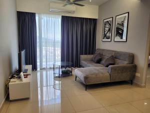 a living room with a couch and a television at Venus Cozy Home in Seri Manjung