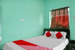 a bedroom with a bed with red pillows and a window at OYO Flagship 81188 New Sharda Homes in Bilāspur