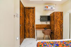 a bedroom with a wooden door and a desk at FabHotel The Hastings Club in Kolkata
