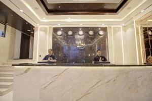 twee personen aan een balie in een hotellobby bij Cygnett Collection K K Hotel in Faizābād