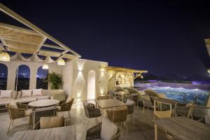 een patio met tafels en stoelen en een zwembad bij Cygnett Collection K K Hotel in Faizābād