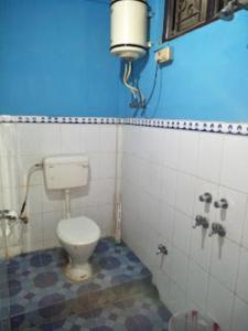 baño con aseo y pared azul en Hotel Dirang Buddha Dirang en Dirang Dzong