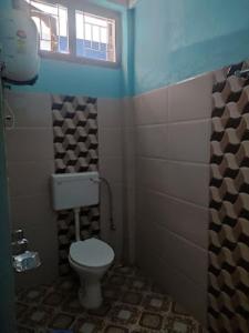 a small bathroom with a toilet and a window at Hotel Dirang Buddha Dirang in Dirang Dzong