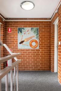 una pared de ladrillo con una pintura en la pared en MAC St Kilda by Melbourne Apartment Collection, en Melbourne