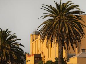a yellow building with a palm tree in front of it at MAC St Kilda Blessington St by Melbourne Apartment Collection in Melbourne +6 photos