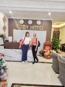 duas mulheres em pé em frente a um hotel em RUBY HOTEL Vĩnh Long em Vinh Long