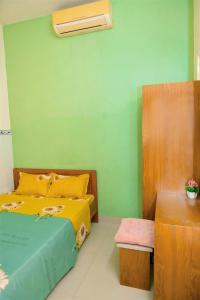 ein Schlafzimmer mit einem Bett und einer grünen Wand in der Unterkunft LUCKY HOME in Nha Trang