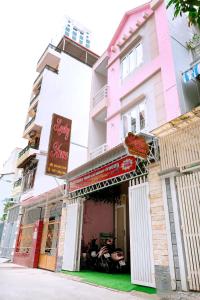 ein rosafarbenes Gebäude mit einem Restaurant mit einem Schild darauf in der Unterkunft LUCKY HOME in Nha Trang