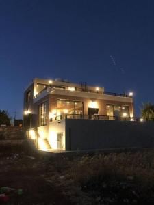 ein nachts beleuchtetes Haus mit Licht in der Unterkunft Dolunay jarash in Gerasa