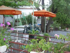 a patio with tables and umbrellas and flowers at Стаи за гости ЖАНА in Varna City +50 photos