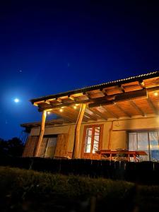 a house with a lit up deck at night at La adorable in Los Reartes
