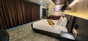 a hotel room with a bed and a couch at The Room Boutique Hotel in Sakon Nakhon