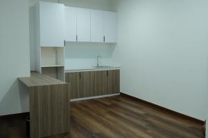 uma cozinha com lavatório e piso em madeira em UniHome Suite em Bintulu