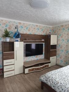 un dormitorio con un centro de entretenimiento con TV en Dzīvoklis Tukuma centrā, en Tukums