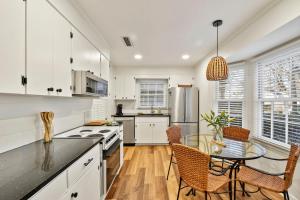 une cuisine avec des armoires blanches et une table et des chaises dans l'établissement Oceanwood 106, à Île de Saint-Simon