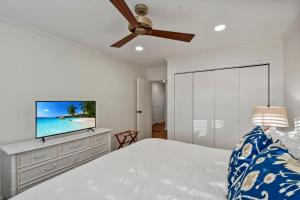 a bedroom with a bed and a flat screen tv at Oceanwood 106 in Saint Simons Island