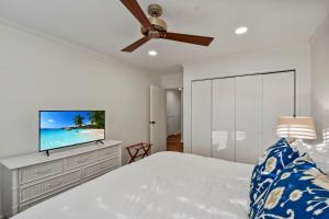 une chambre avec un lit et une télévision à écran plat dans l'établissement Oceanwood 106, à Île de Saint-Simon