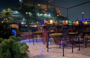 een tafel met stoelen en verlichting op een patio in de nacht bij Shahi Guest House in Jodhpur