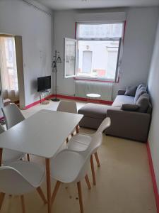 ein Wohnzimmer mit einem Sofa, einem Tisch und Stühlen in der Unterkunft ++++ CENTRAL charmant 70m2 avec balcon, mer à 200 m et rue piétonne à 300 m ++++ in Berck-sur-Mer