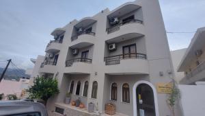 a white building with balconies on the side of it at Amaryllis Hotel in Karpathos