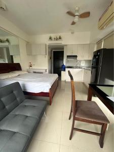 um quarto com uma cama, um sofá e uma cozinha em Mabolo Garden Flats em Cebu