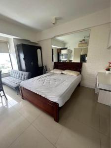 um quarto com uma cama grande e um sofá em Mabolo Garden Flats em Cebu