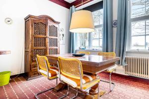jadalnia z drewnianym stołem i krzesłami w obiekcie Stately Apartment Incl, Consumption w mieście Bogense