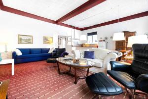 a living room with a blue couch and a table at Stately Apartment Incl, Consumption in Bogense