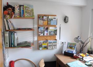 Zimmer mit einem Schreibtisch und Regalen mit Büchern in der Unterkunft Ferienhaus EMMA in Kleinern