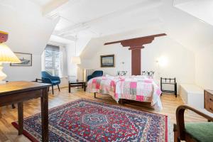 a bedroom with a bed and a table and a rug at Stately Apartment Incl, Consumption in Bogense