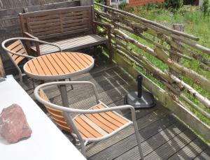 eine Terrasse mit 2 Stühlen, einem Tisch und einer Bank in der Unterkunft Ferienhaus EMMA in Kleinern