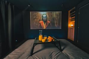 um quarto com uma cama e uma mesa com sumo de laranja em Cinéma ROOM l'unique expérience em Saint-Étienne