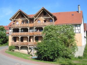 una grande casa di legno con un ponte su una strada di Bauernhofpension Büchsenschütz a Harbshausen