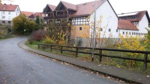 una strada di fronte a una casa con una recinzione di Bauernhofpension Büchsenschütz a Harbshausen