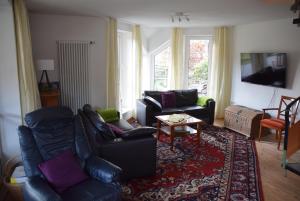 - un salon avec deux canapés et un tapis dans l'établissement Ferienhaus SonnenFänger, à Hemfurth-Edersee