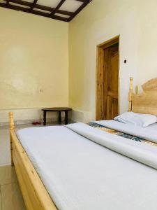Rubavu的住宿－Ignite guest and apartment，一间卧室设有两张床、一张桌子和一扇门