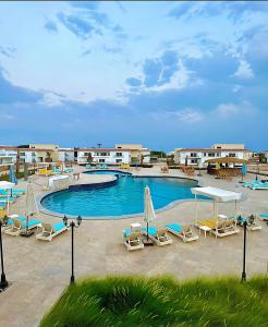 una piscina con sedie e ombrelloni in un resort di Babushka Boutique Hotel-Dahab a Dahab