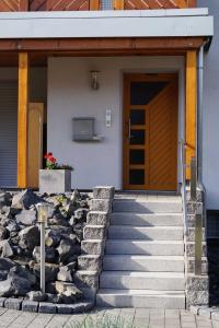 La porte d'entrée d'une maison est accessible par des escaliers. dans l'établissement Ferienwohnung am Eckerich, à Fritzlar