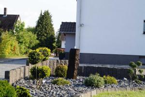 a garden with rocks and plants in front of a building at Ferienwohnung am Eckerich in Fritzlar