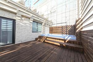 un balcone con panca in legno e un edificio di HOUND HOTEL sasang branch a Busan