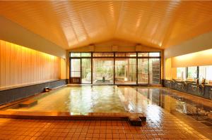 新泻Koshi no yado Takashimaya的带有大窗户的建筑内的游泳池