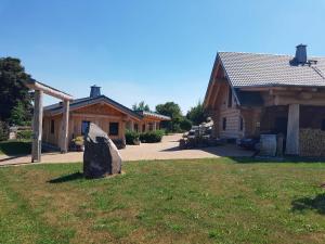 a rock sitting in the grass in front of a house at Steirer-Hof in Vöhl