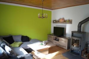 sala de estar con sofá y chimenea en Ferienwohnung am Eckerich, en Fritzlar