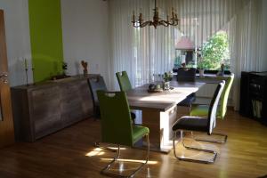 cocina con mesa de madera y sillas verdes en Ferienwohnung am Eckerich en Fritzlar