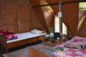 的住宿－Namdapha Jungle Camp Miao，小房间设有两张床和一张桌子
