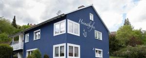 ein blaues Haus mit Schreiben auf der Seite in der Unterkunft Ferienwohnungen Heimathafen in Edersee