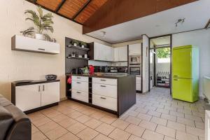una cucina con armadi bianchi e frigorifero verde di Oemoemenoe - 6 pers - sauna - optionele Jacuzzi beschikbaar sep tm jun a Kortgene