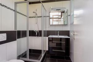 un bagno con doccia in vetro e lavandino di Oemoemenoe - 6 pers - sauna - optionele Jacuzzi beschikbaar sep tm jun a Kortgene Altre 18 foto