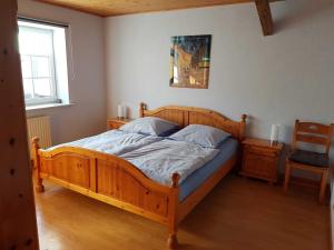 een slaapkamer met een houten bed en een raam bij Ferienwohnung "Zum Alten Römer" in Kleinern