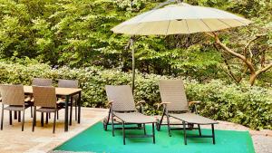 a table and chairs with an umbrella on a patio at Ferienwohnung Wald & See in Bringhausen